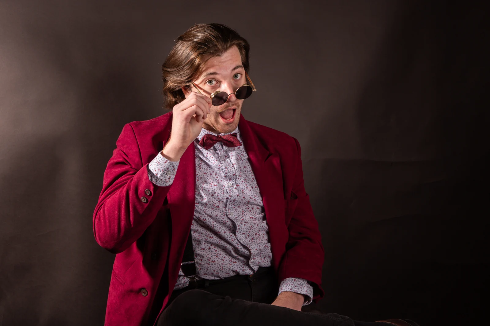Štěpán Chalupa v červeném saku a kulatých brýlích
