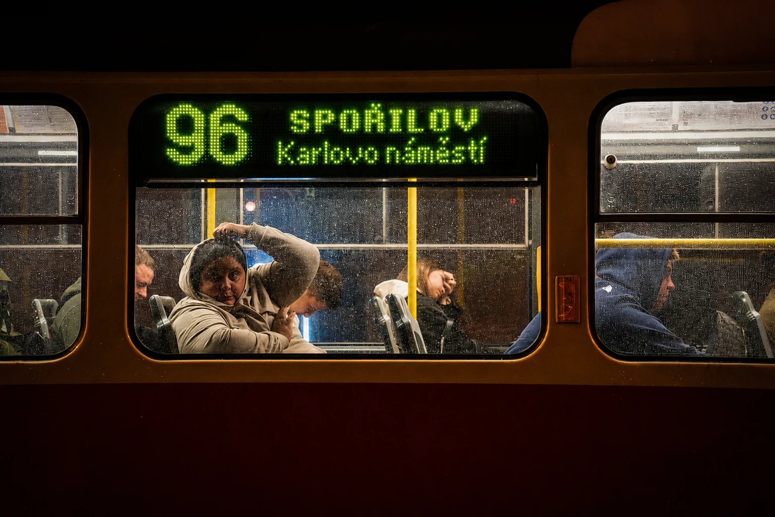 Krátké spojení za oknem noční tramvaje.