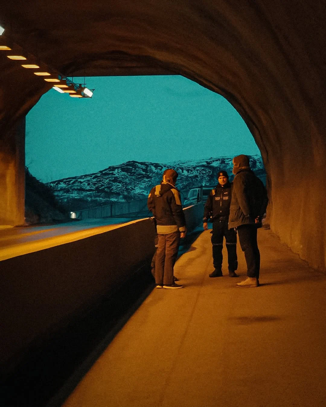 Oranžové světlo tunelu a modrý den za ním.